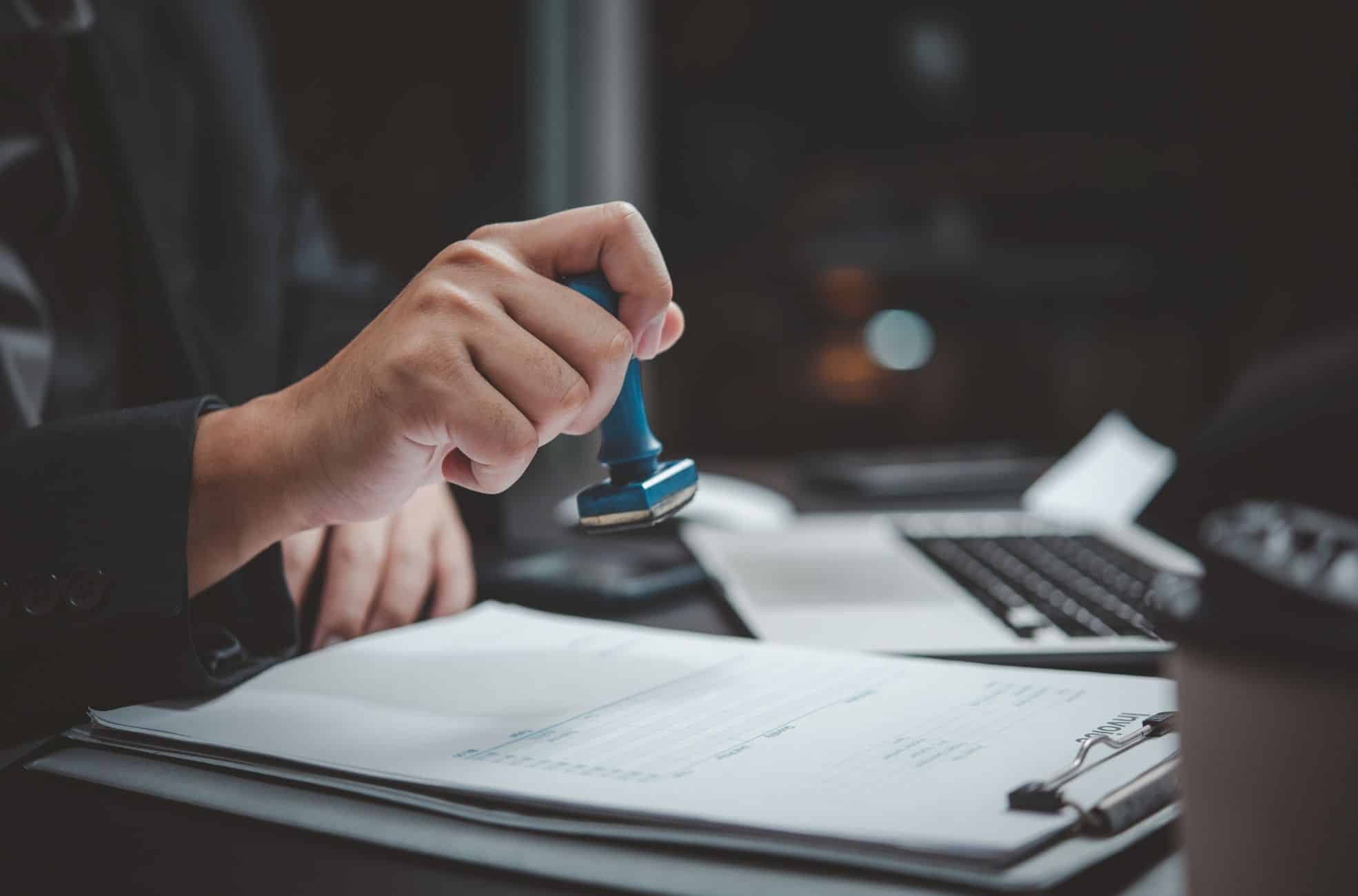 Official stamping and approval - blue rubber stamp over documents