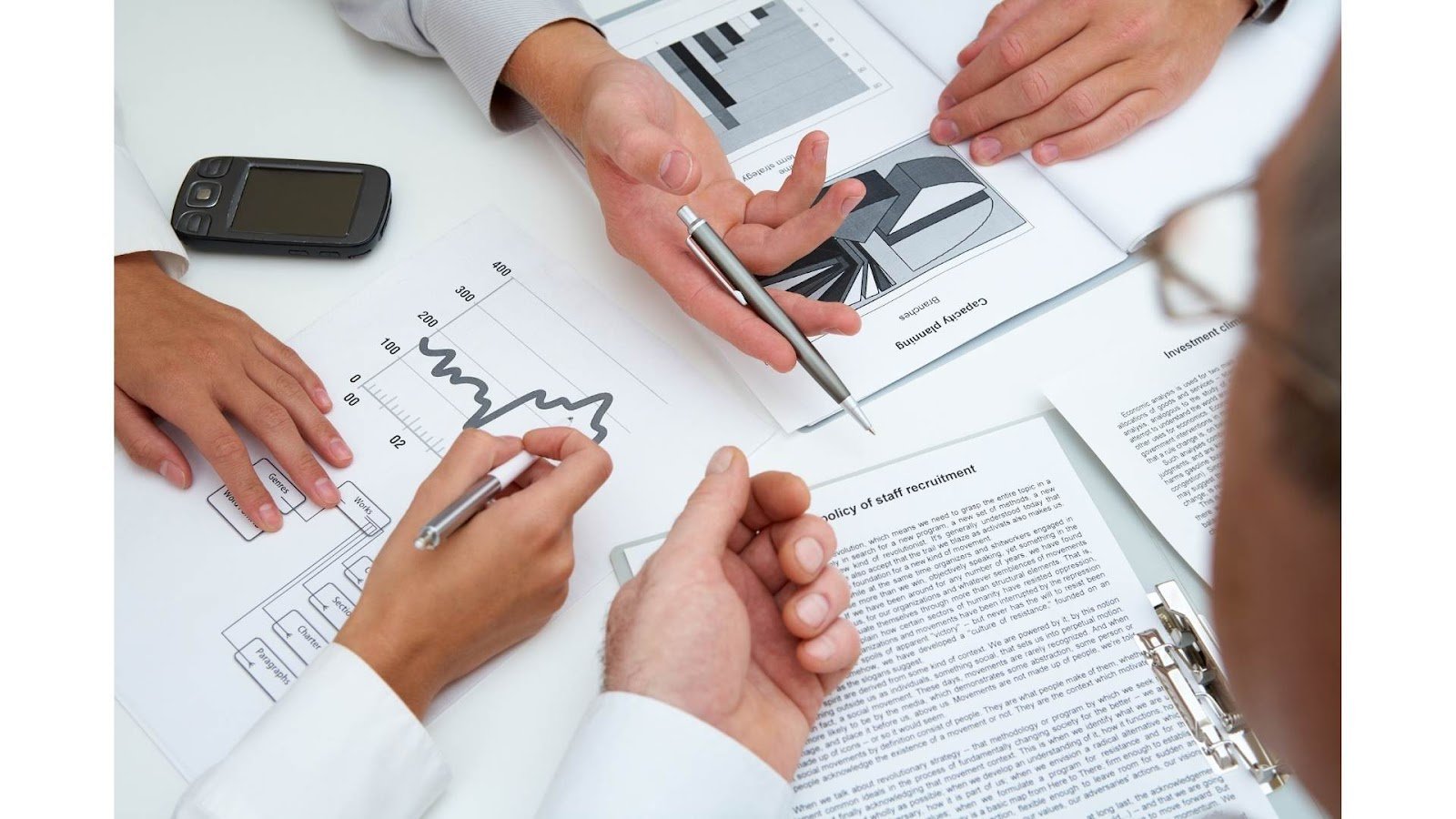 Business analysis and planning - hands working with documents and charts